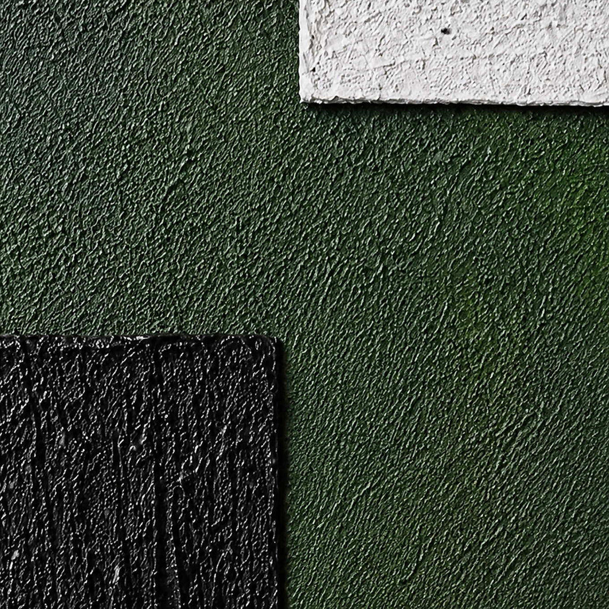 Close view of coarse green texture, raised white paint, and deep black ridges.