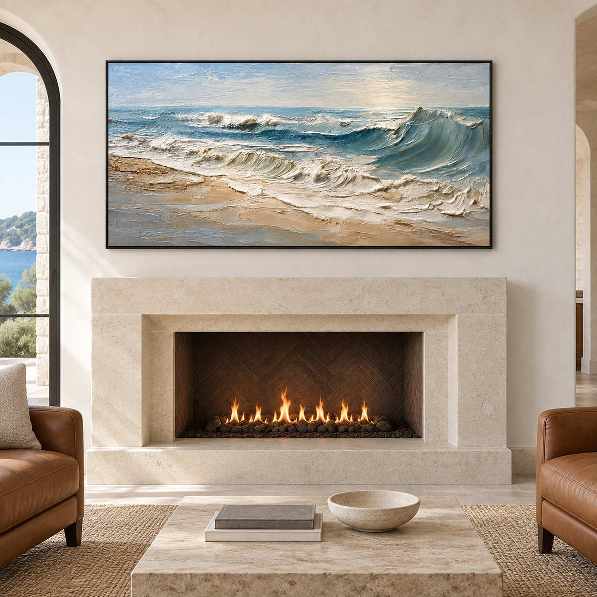 Coastal wave painting above a lit pale fireplace between brown armchairs.
