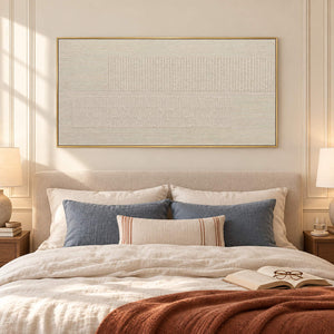 Panoramic ivory relief painting with fine grooves and geometric fields in a gold frame in a bedroom.