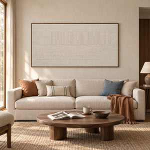 Panoramic ivory relief painting with fine grooves and geometric fields in a brown wood frame in a living room.