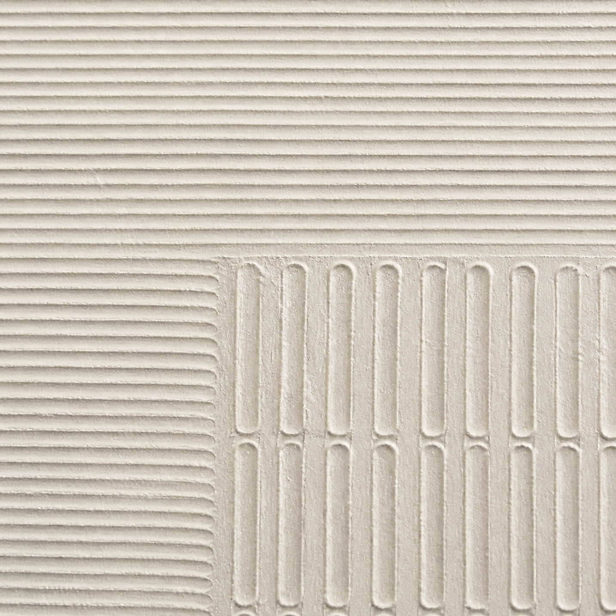 Close-up of sculpted ivory grooves and recessed geometric relief.