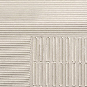 Close-up of sculpted ivory grooves and recessed geometric relief.