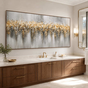 Wood framed gold and gray artwork above a bathroom vanity beside a wall mirror.