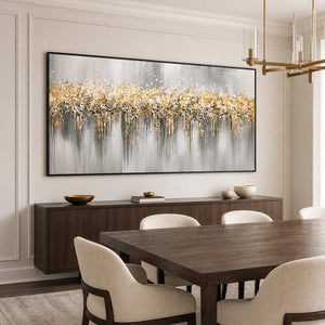 Black framed gold and gray abstract painting beside a dark wooden dining table.