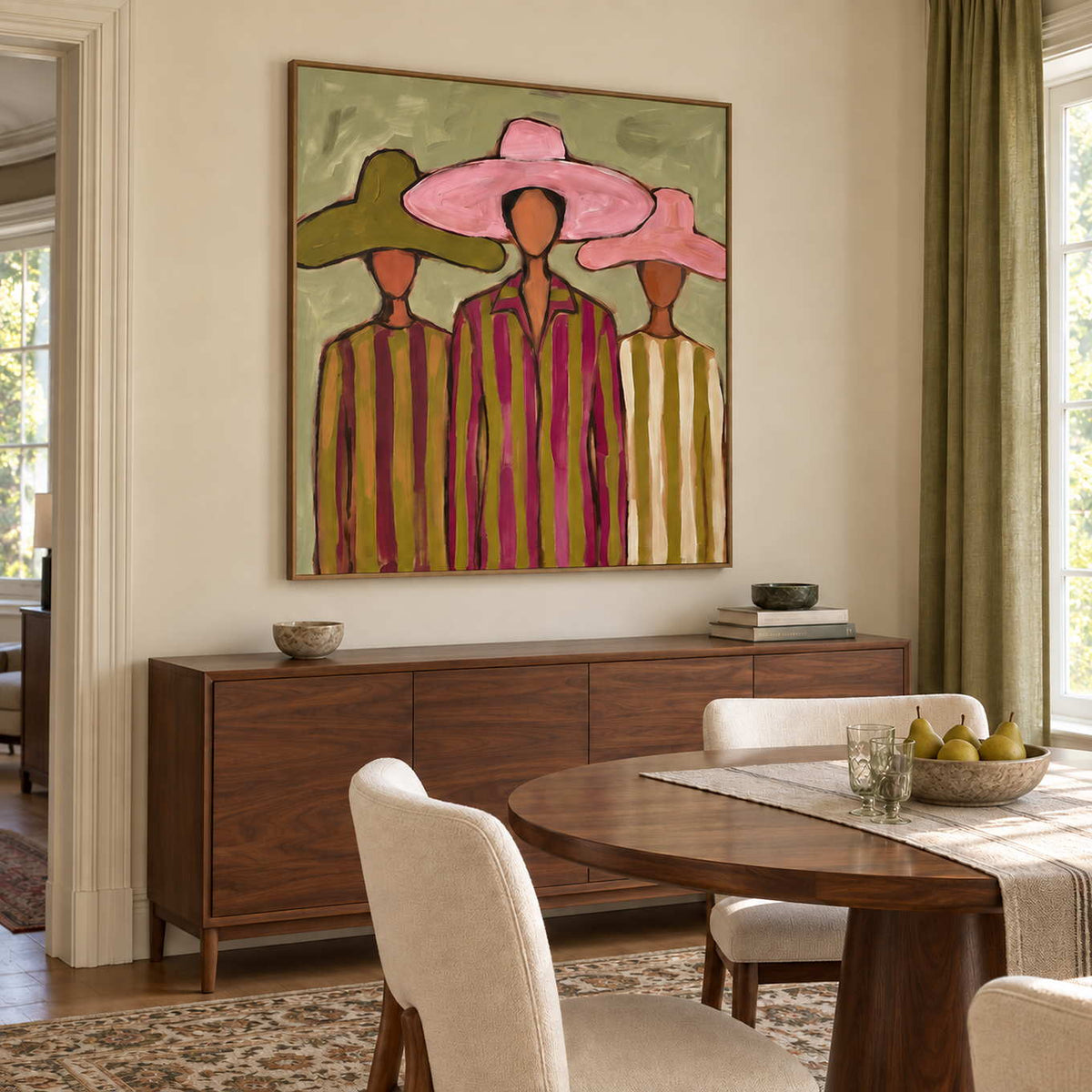 A Meeting in Style in a wood frame above a sideboard beside a round wood dining table and cream chairs.