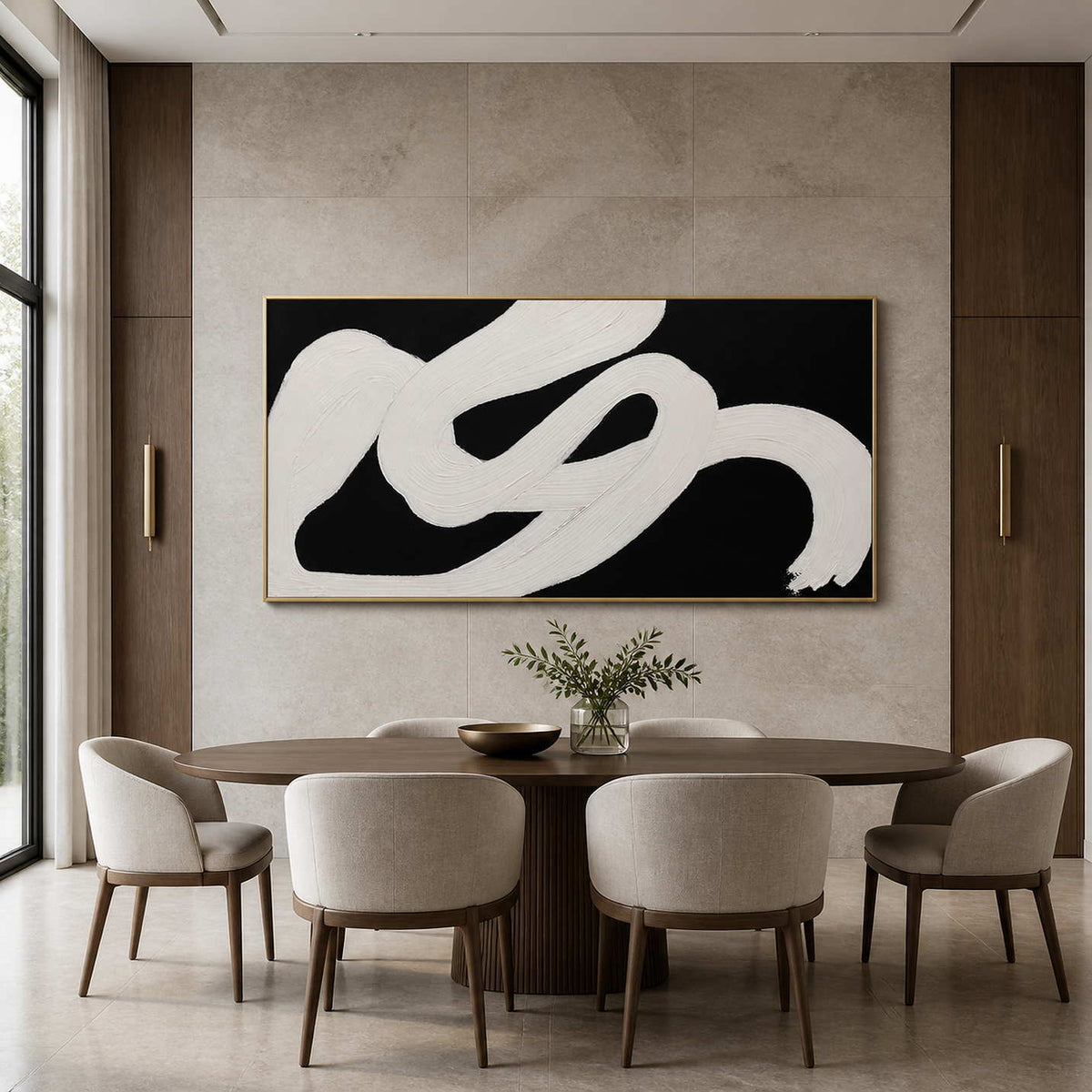Gold framed black and white panoramic painting above an oval wooden dining table.