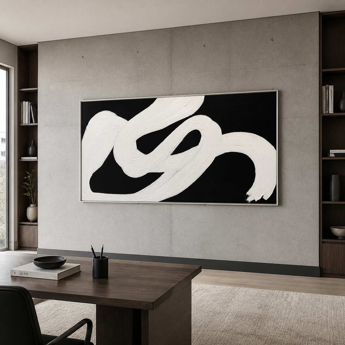 Silver framed panoramic abstract painting behind a desk between bookshelves in a modern study.