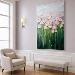 White framed pink flower painting above a pale bench beside an armchair in a lounge.