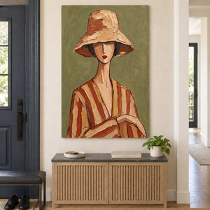 Tall olive portrait above a slatted wooden entryway cabinet and a small plant.
