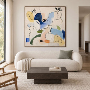 Loose black outlines and blue, yellow and green abstract shapes in a brown wood frame, displayed above a sofa in a living room.