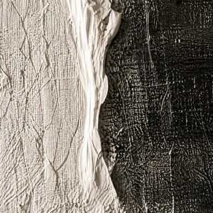 Close view of an uneven ivory paint edge, fine scraped lines, and a dark surface.