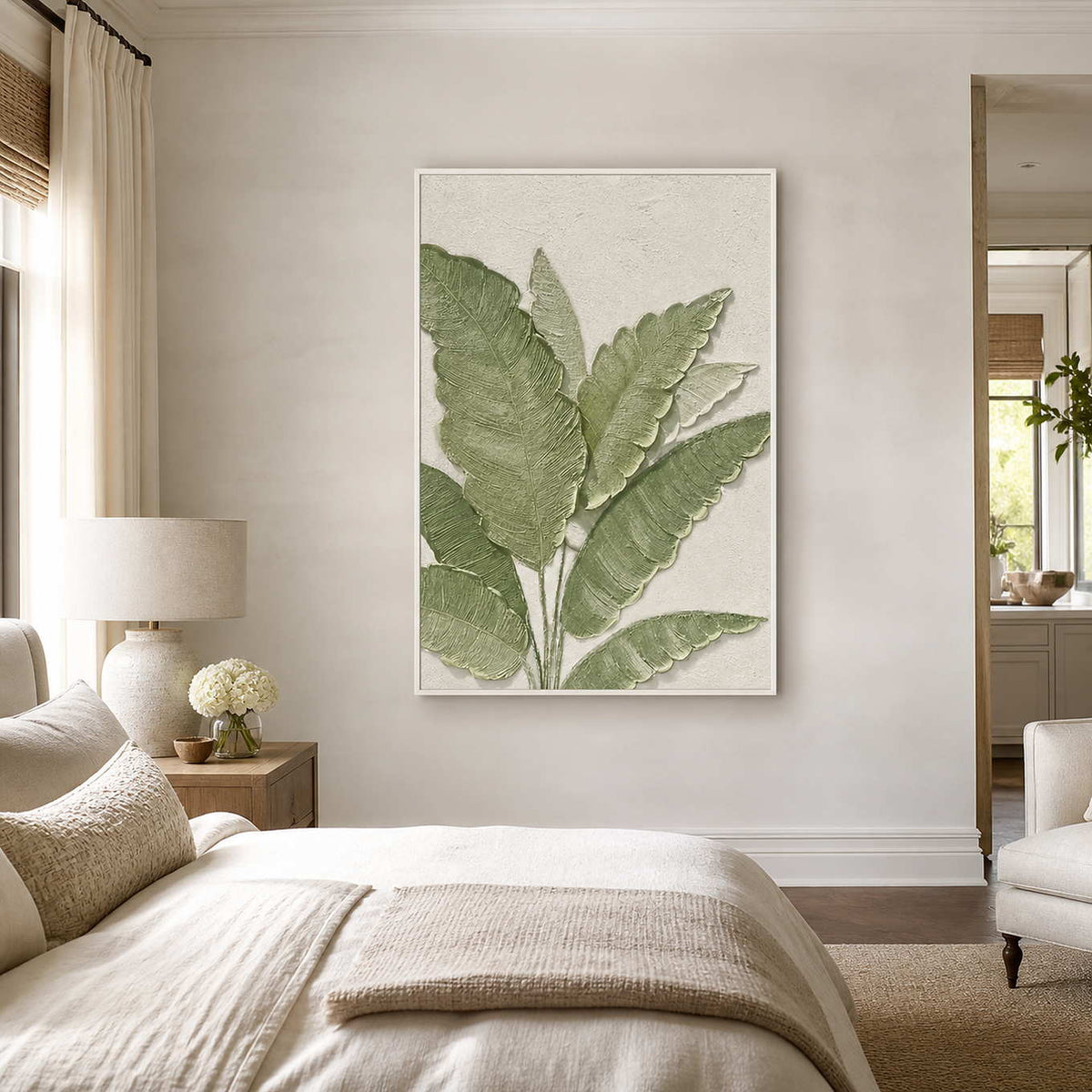 White-framed green leaf wall art displayed beside a bed in a calm neutral bedroom.