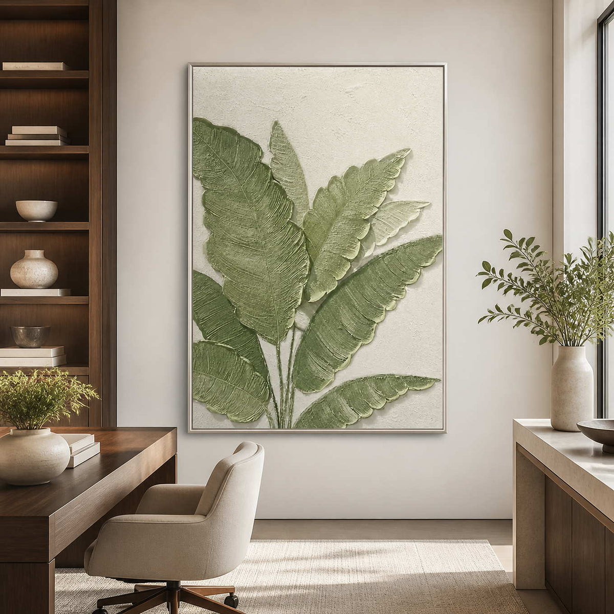 Silver-framed botanical wall art beside a wooden desk in a bright home office.