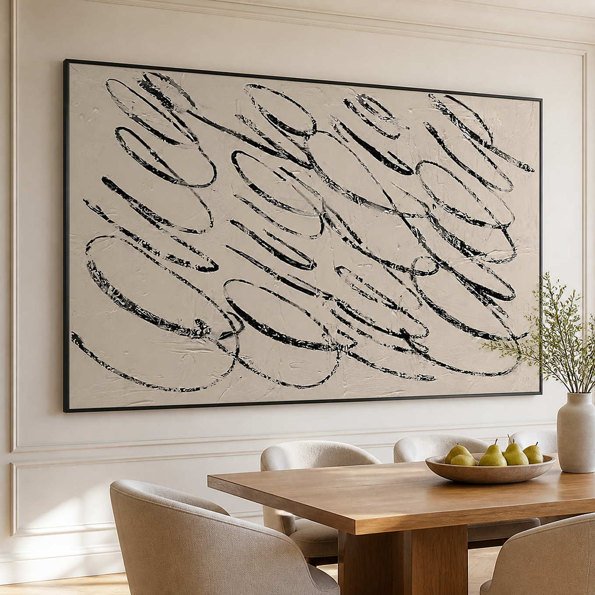 Black framed looping abstract painting above a wooden dining table with pears.