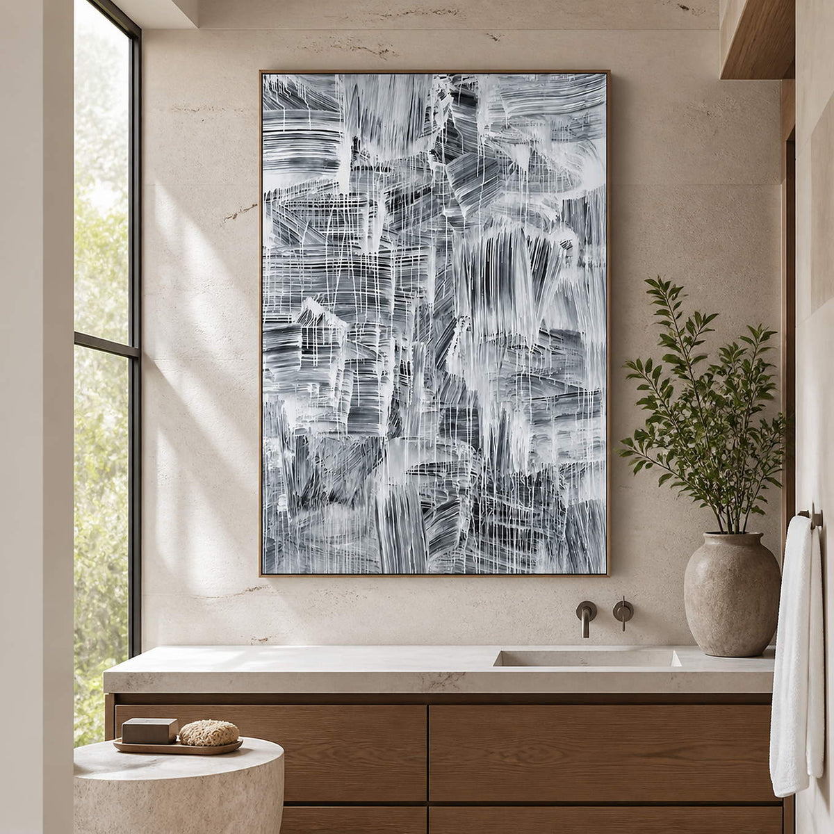 Tall gray-and-white artwork above a bathroom vanity beside a window.