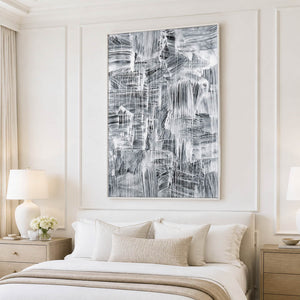 White-framed vertical abstract painting above a neutral upholstered bed.
