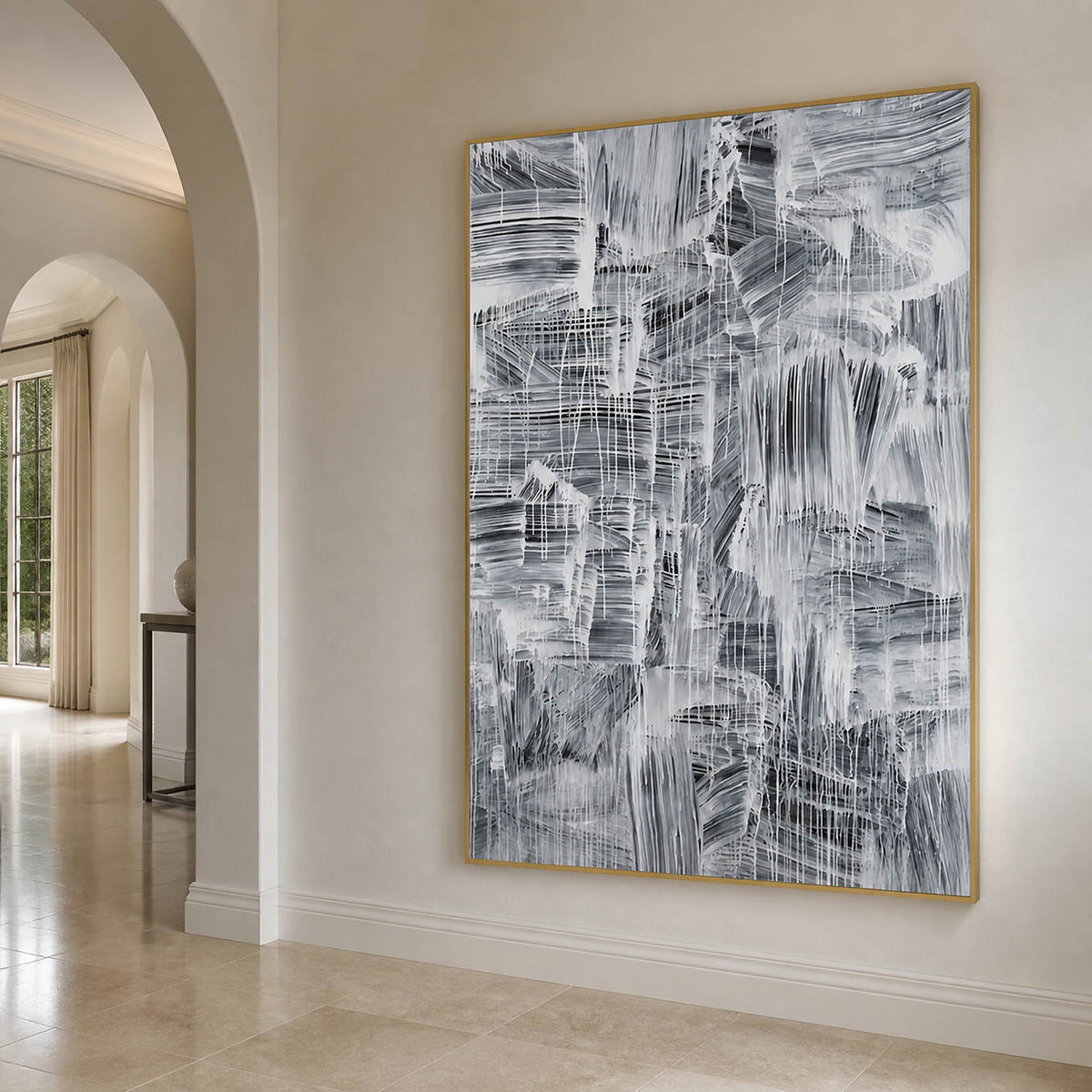 Gold-toned framed gray abstract artwork beside an arched hallway opening.