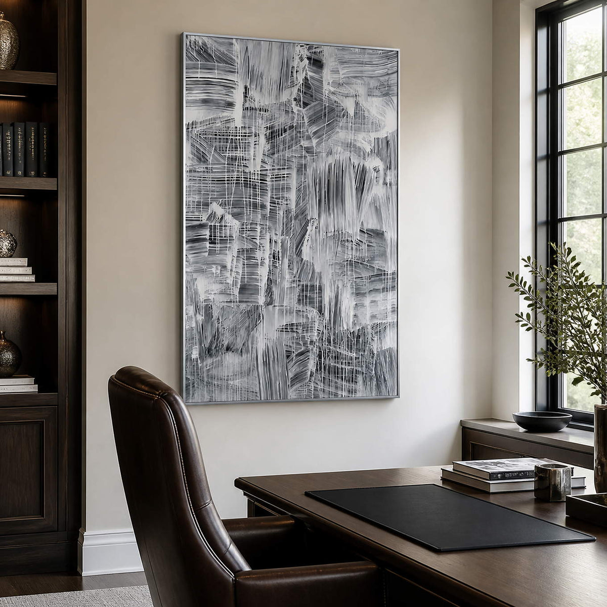 Monochrome abstract painting beside a study desk, dark bookcase, and tall window.