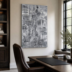 Monochrome abstract painting beside a study desk, dark bookcase, and tall window.