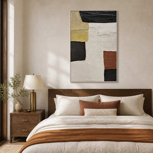 White-framed abstract artwork above a wood bed with cream bedding and a warm rust-colored throw.