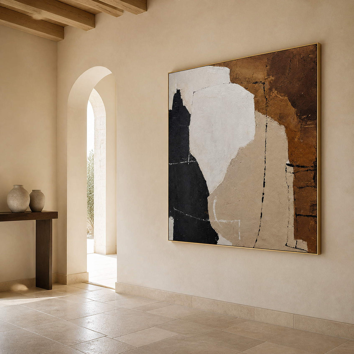Gold-toned framed abstract painting on a pale hallway wall beside an arched doorway.