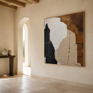 Gold-toned framed abstract painting on a pale hallway wall beside an arched doorway.
