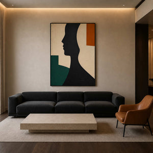 Minimalist black profile wall art above a dark modern living room sofa.