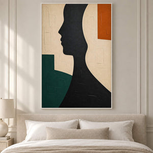 Hand-painted black profile canvas with ivory, green, and orange forms, displayed in a bedroom in a white frame.