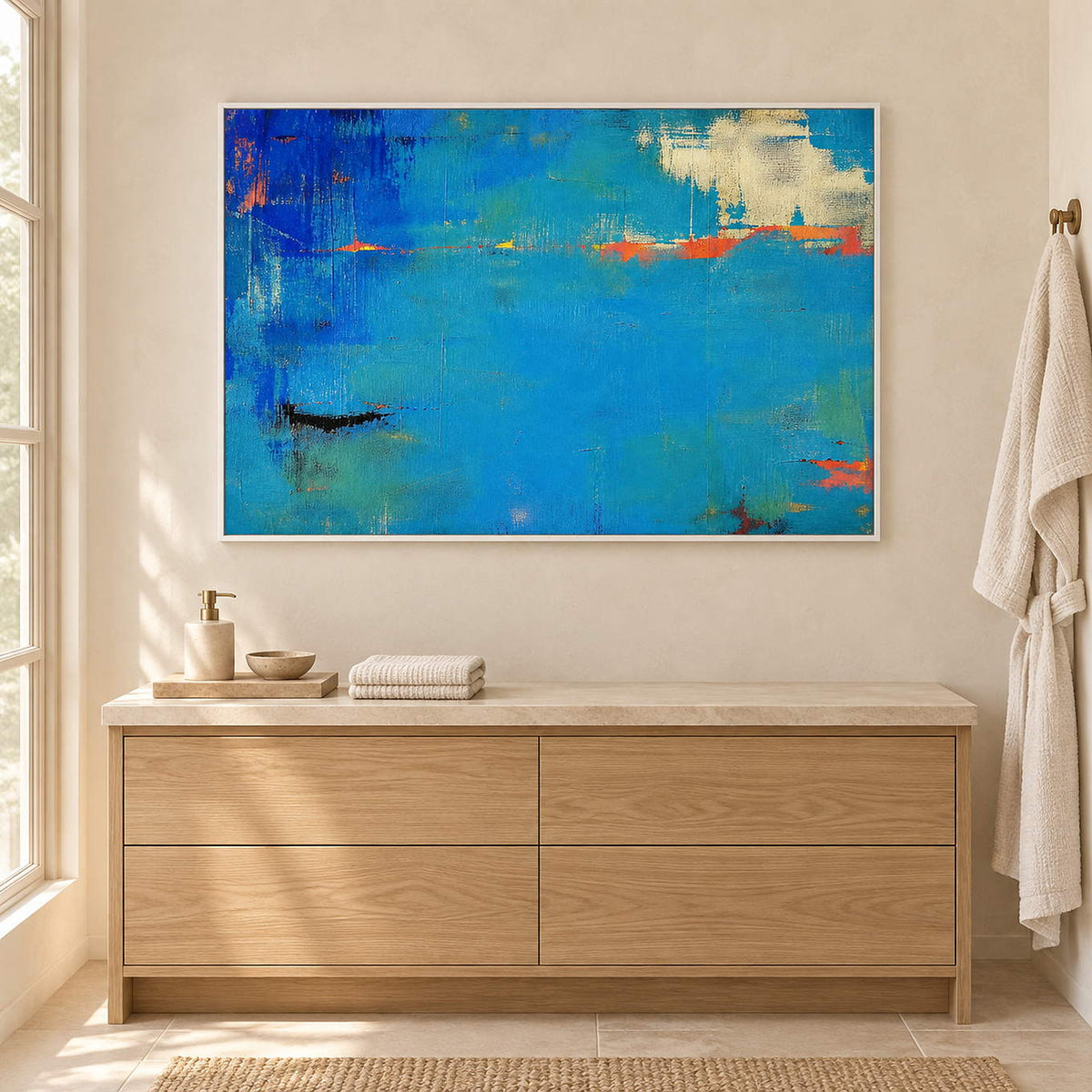 Blue and turquoise abstract painting with narrow orange streaks in a white frame beside a bathroom vanity.