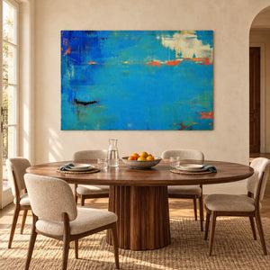 Blue and turquoise abstract painting with narrow orange streaks without an outer frame in a dining room.