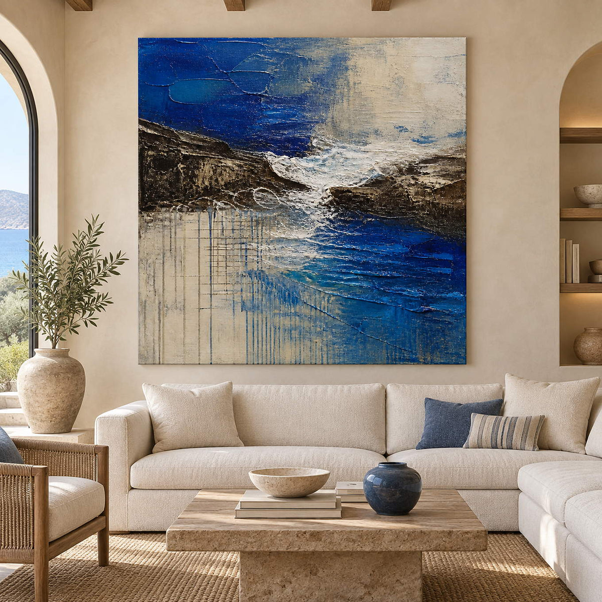 Square cobalt sea, dark rock, and ivory surf textured painting, displayed in a living room without an outer frame.