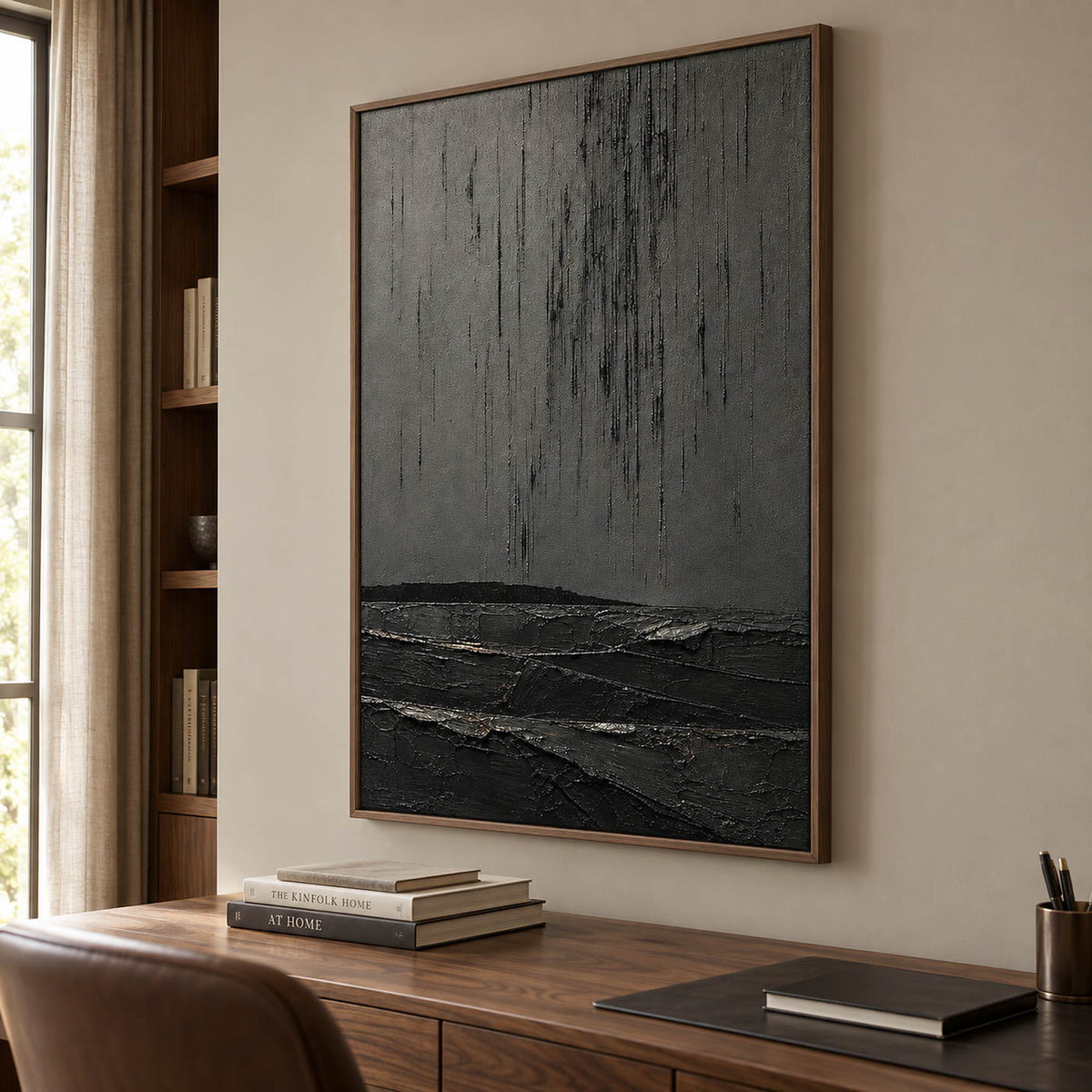 Charcoal rain marks descending over sculpted black terrain in a vertical composition, displayed in a study in a brown wood frame.