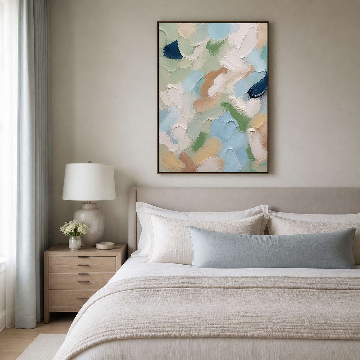 Pastel textured painting creates gentle color above a neutral bed.