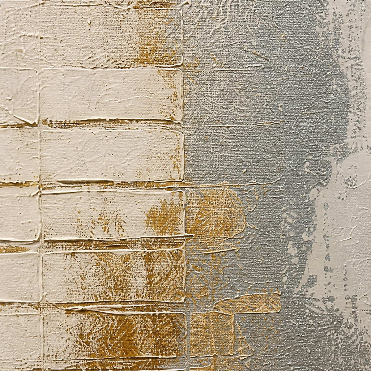 Close-up of raised ivory blocks, silver washes, and warm gold texture.