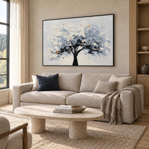 A Quiet Guardian in a black frame above a beige sofa and rounded stone coffee table in a sunlit living room.