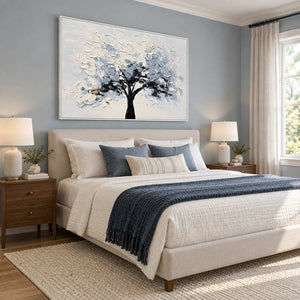 A Quiet Guardian in a white frame above a neutral bed with blue-gray pillows and a dark knitted throw.