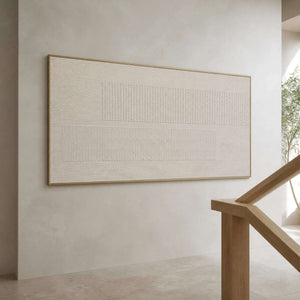 Wide neutral relief artwork displayed beside a pale wood staircase.