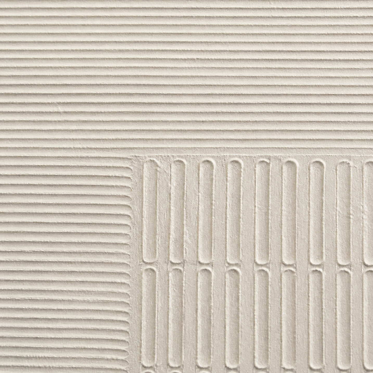 Close-up of sculpted ivory grooves and recessed geometric relief.