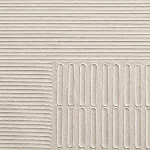 Close-up of sculpted ivory grooves and recessed geometric relief.