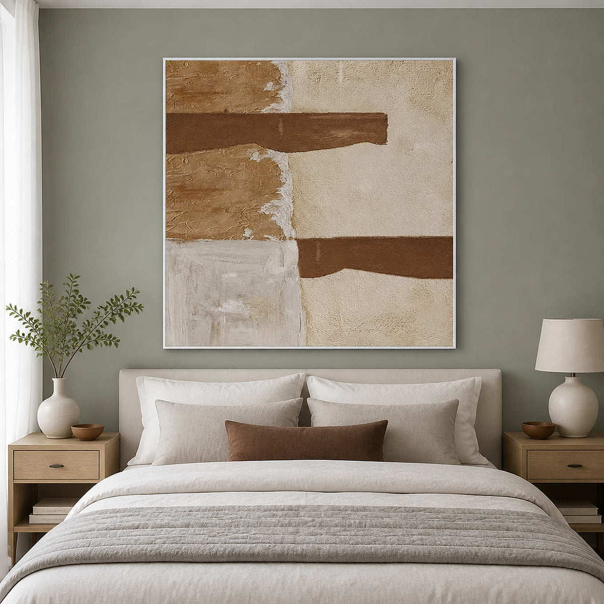 White framed earthy abstract painting above a pale upholstered bedroom headboard.
