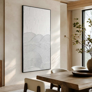 Black framed white abstract artwork beside a wooden dining table.