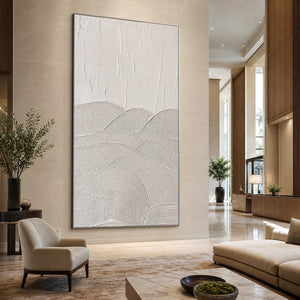 Silver framed white abstract artwork beside lounge seating in a contemporary hotel lobby.