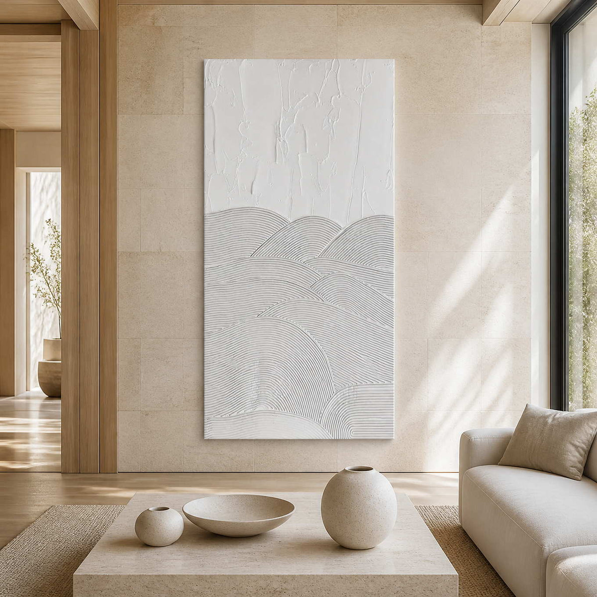 Frameless white textured artwork beside neutral seating in a sunlit living room.