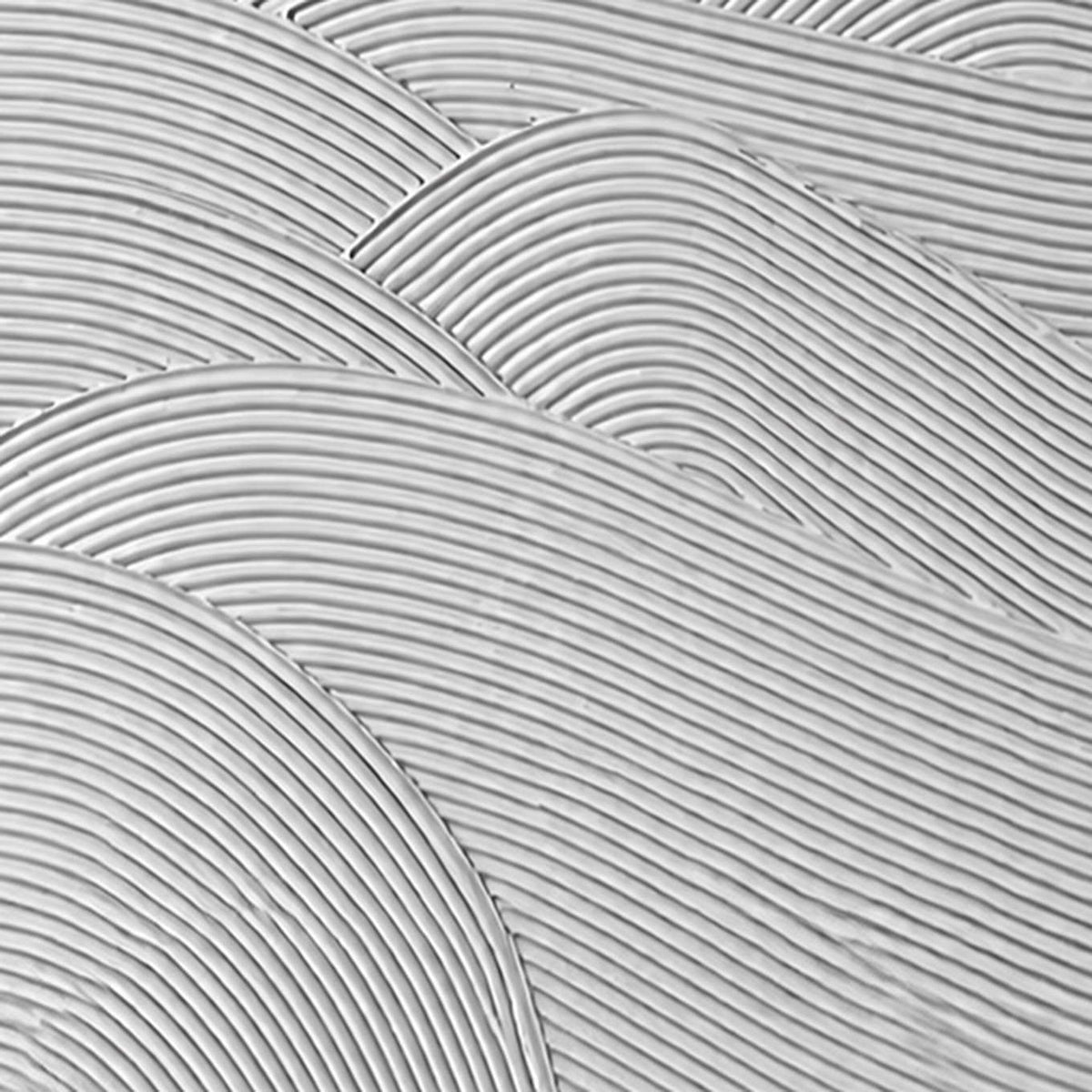 Close view of fine parallel grooves forming overlapping waves in white texture.