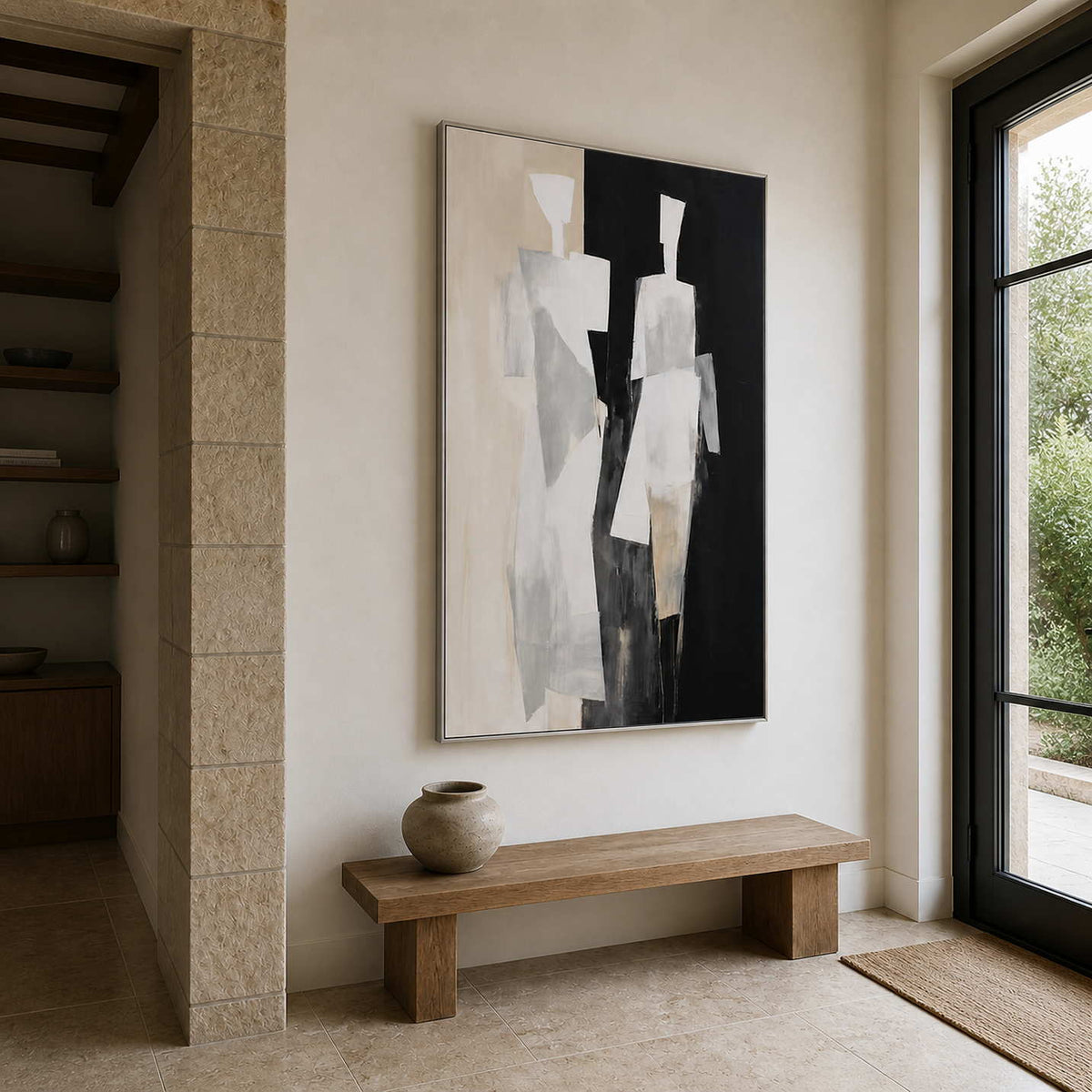 Silver framed painting of two figures above a wooden bench in a stone entryway.