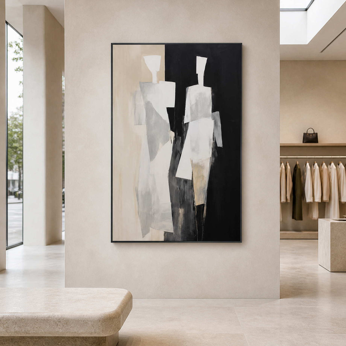 Black framed minimalist figurative artwork on a pale wall in a retail gallery.