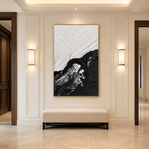 Gold framed tidal artwork above an upholstered bench between warm hallway wall lights.