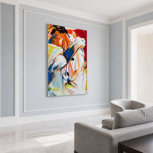 Silver-framed blue and white abstract painting on a pale blue-gray wall beside a light gray sofa.