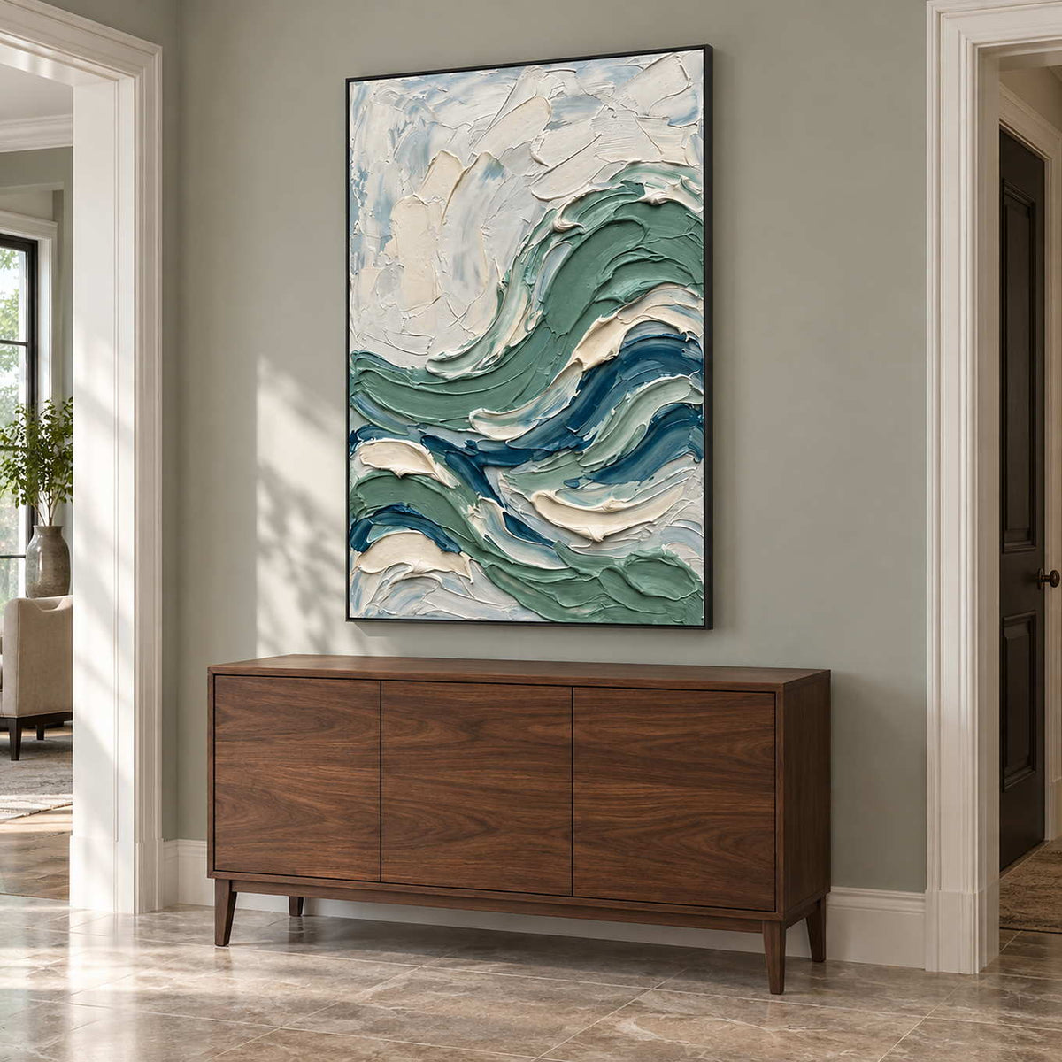 A Sea Breeze in a black frame above a walnut sideboard on a soft gray-green entryway wall.