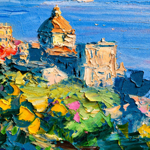 Detail of a domed building, bright foliage, and blue water beyond.
